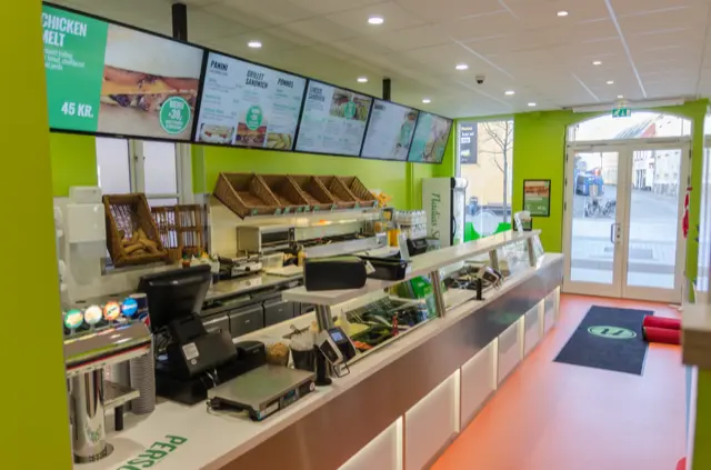 Interiorul restaurantului Nadias cu meniurile digitale montate deasupra tejghelei